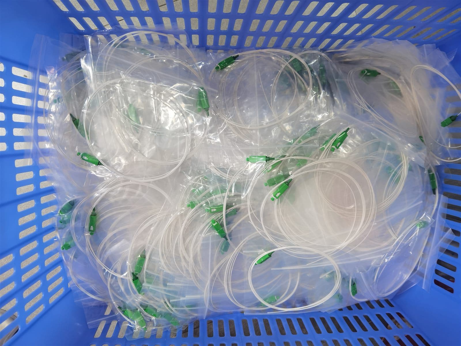 Finished fiber patch cords bagged and staged in a production basket