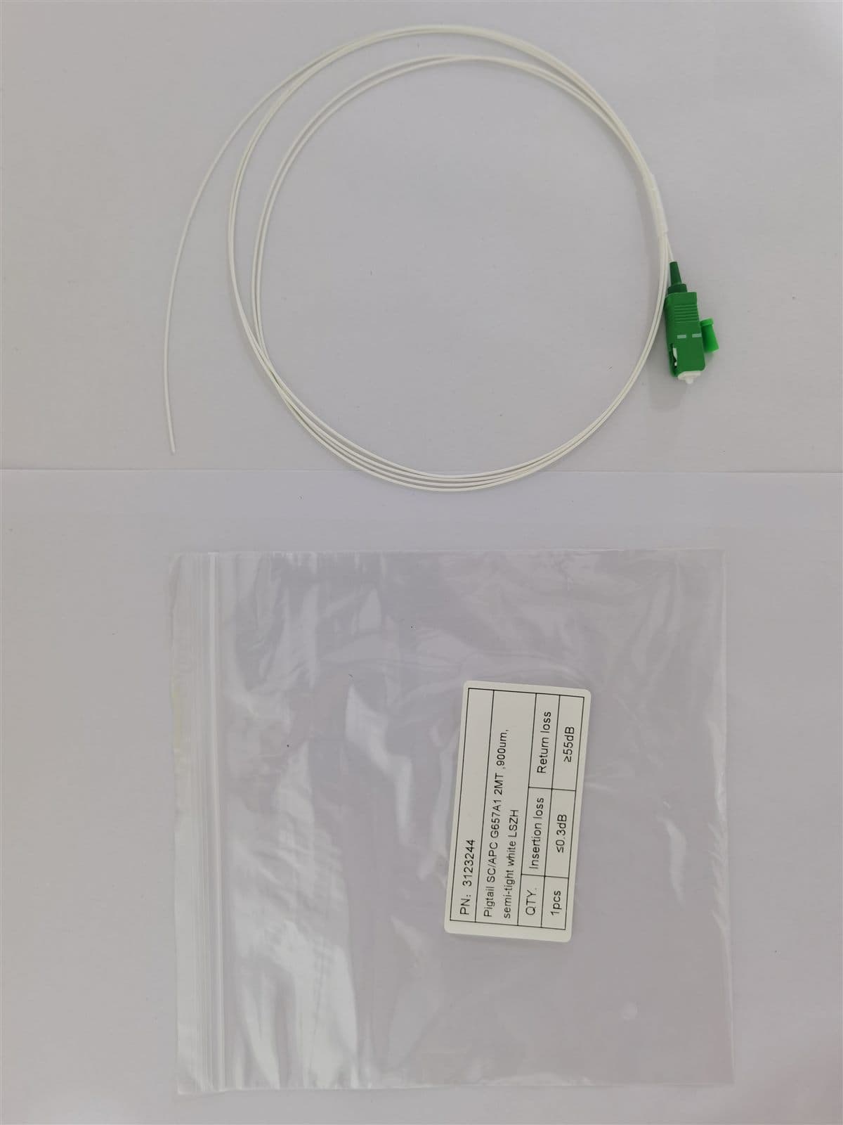 Fiber pigtail in packaging with a printed label showing SC/APC G657A1 2 m LSZH specifications